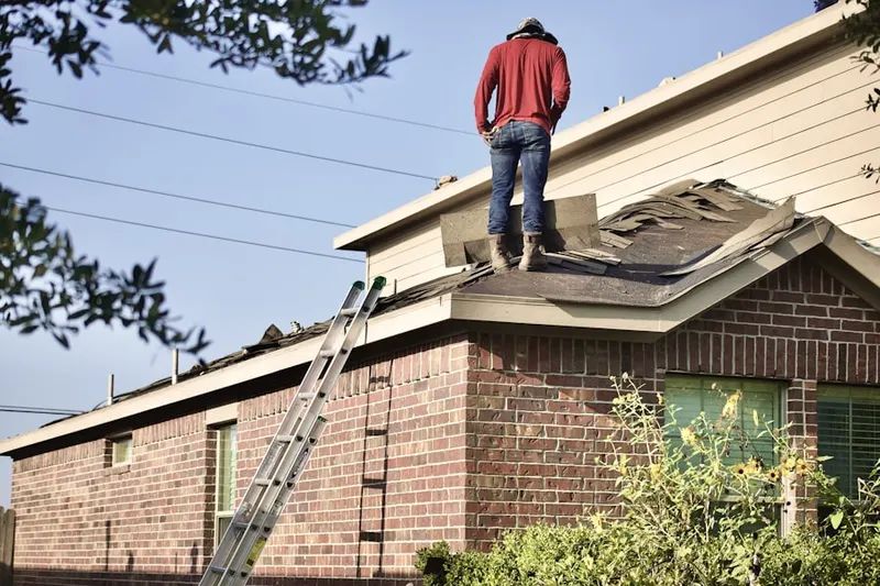 Professional roofer working on a residential roof in Sully Plantation